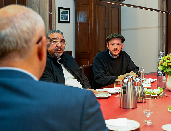 Kurt Tallert (re.) beschreibt Bürgermeister Andreas Bovenschulte (li.) von seinem von den Nazis als Halbjude verfolgten Vater und seinem Buch Spur und Abweg. In der Mitte Marcus Reichert vom Bremer Sinti-Verein.